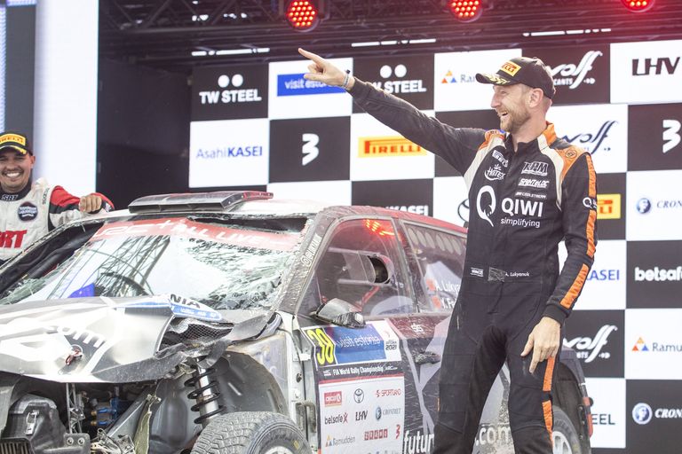 Aleksei Lukjanuk sai Rally Estonia finišipoodiumile sõita naeratus näol. Taustal on tema vigastatud Škoda Fabia.