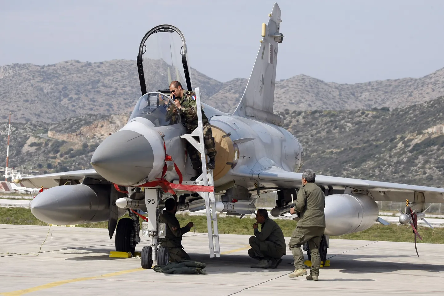 Техники на греческой авиабазе готовят самолет для участия в ливийской операции.