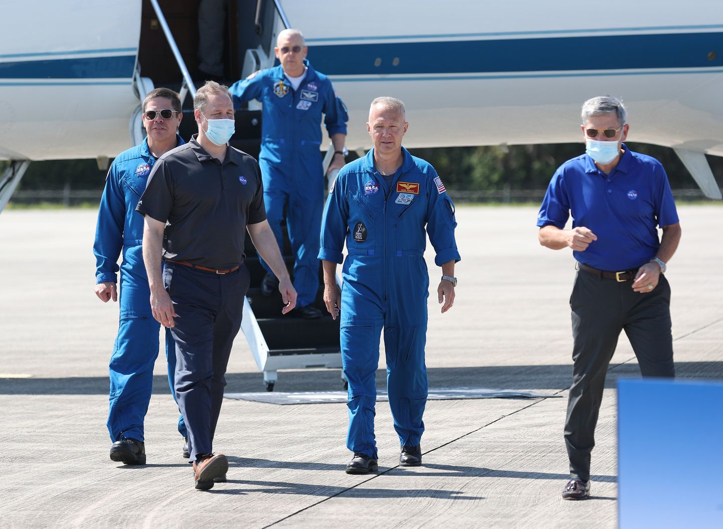 USA kosmoseagentuuri (NASA) astronaudid Bob Behnken (vasakul) ja Doug Hurley (paremalt teine) saabusid Kennedy kosmosekeskusesse, kus neid võtsid koroonaviiruse tõttu näomaskides vastu NASA peadirektor Jim Bridenstine (vasakult teine) ja keskuse direktor Robert Cabana.