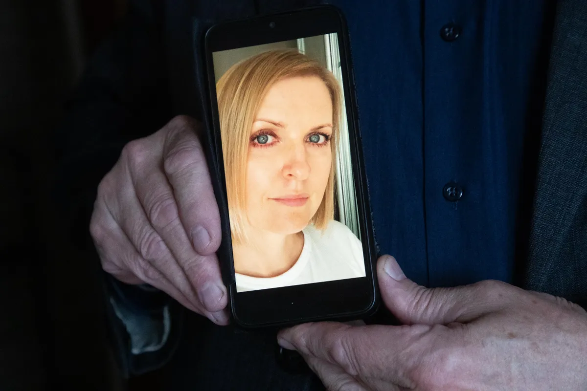 Isa näitab telefonist oma tütre pilti.