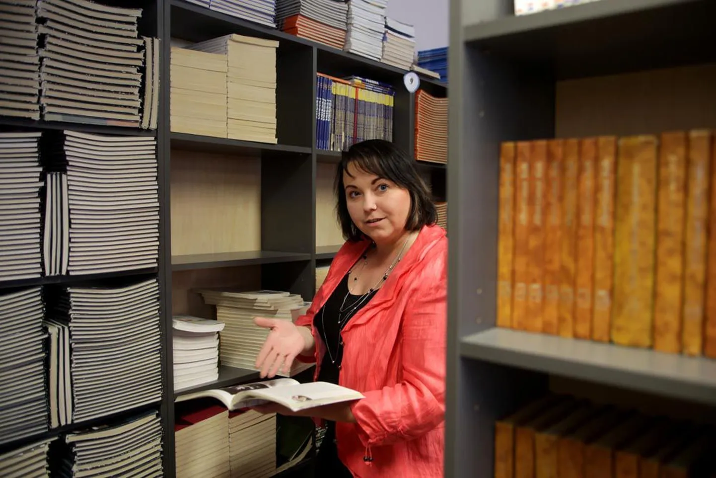 Tartu Kivilinna gümnaasiumi direktor Karin Lukk näitab õpikuid kooli raamatukogus.