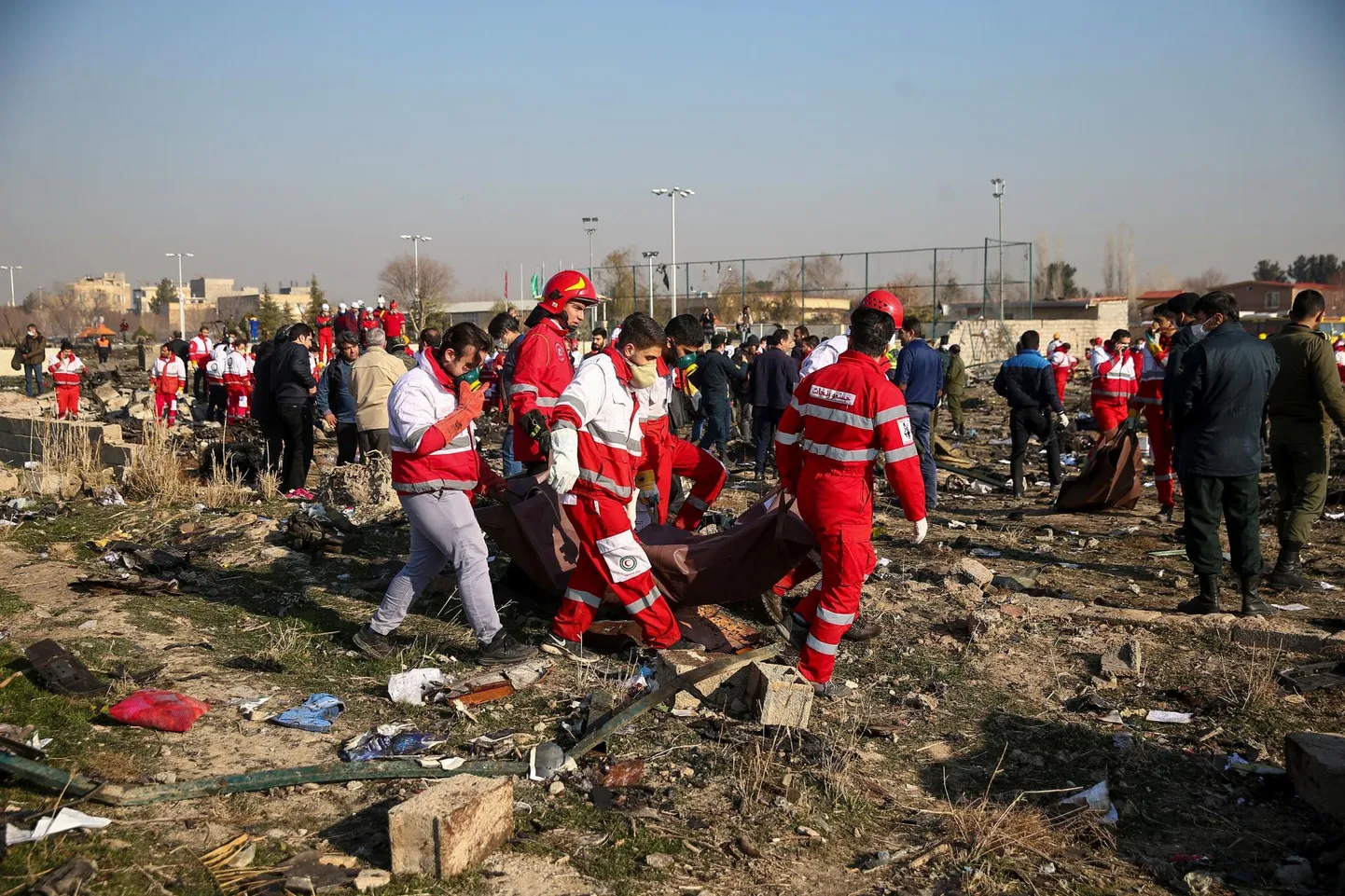Iraani päästetöötajad toimetamas Ukraine International Airlinesi katastroofis hukkunute surnukehi ära õnnetuspaigalt Teherani lennuvälja lähistel.