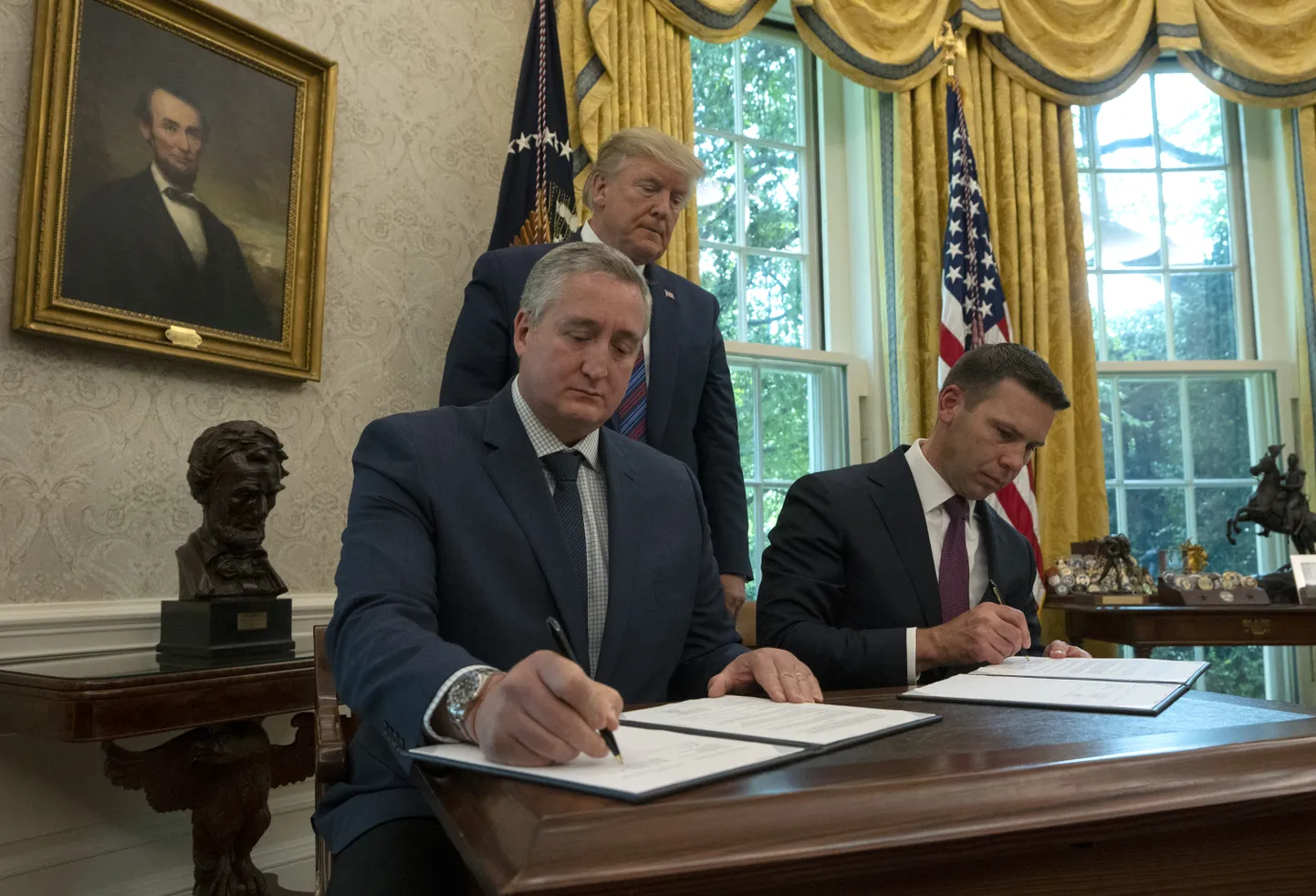 USA sisejulgeolekuministri kohusetäitja Kevin McAleenan (vasakul) ja Guatemala siseminister Enrique Degenhart allkirjastamas reedel Valge Maja Ovaalkabinetis rändelepet, mis kohustab läbi Guatemala Ühendriikidesse jõuda proovivaid migrante taotlema asüüli Guatemalas.
