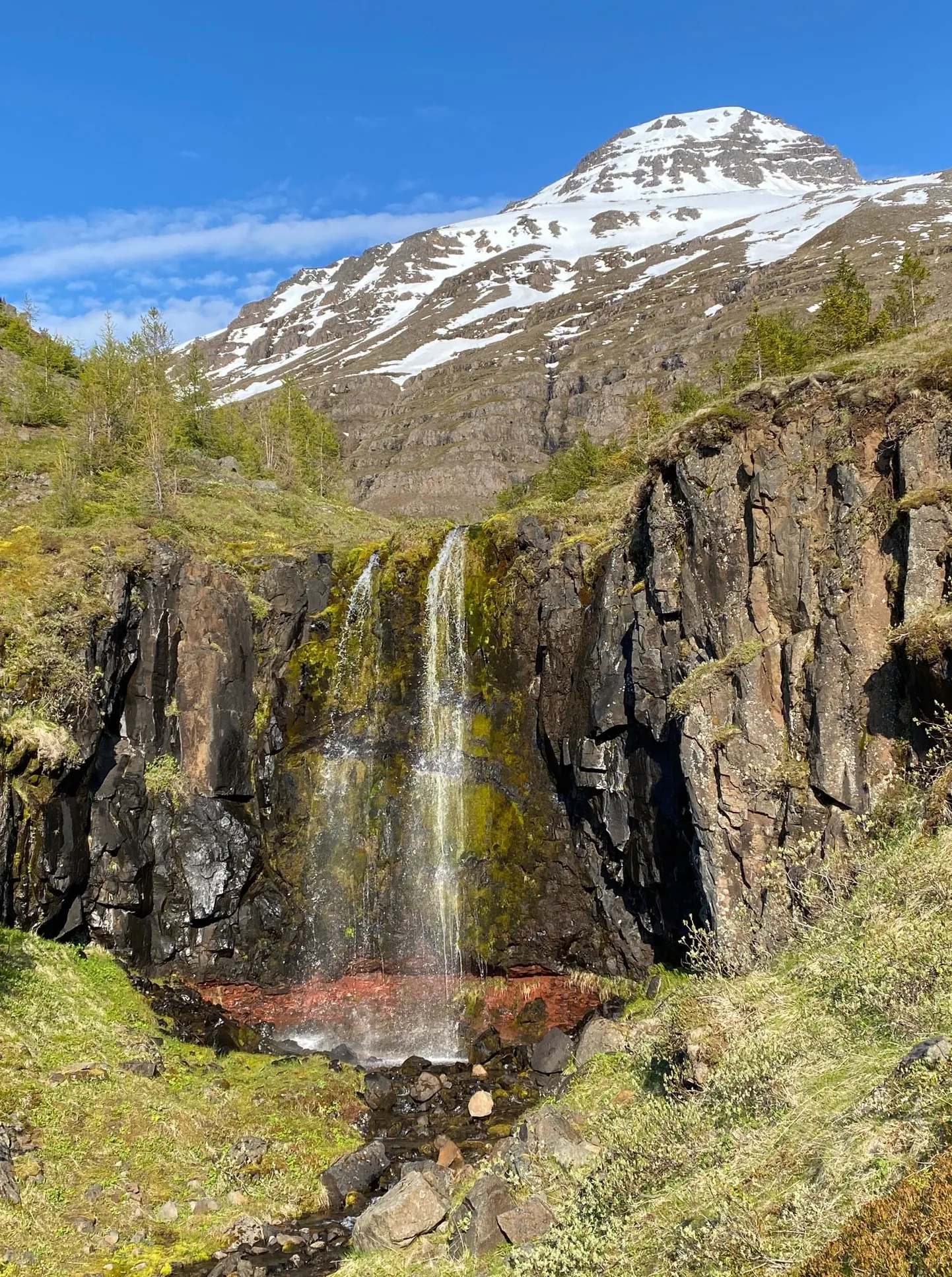 Lumised mäed ja kosk Islandi