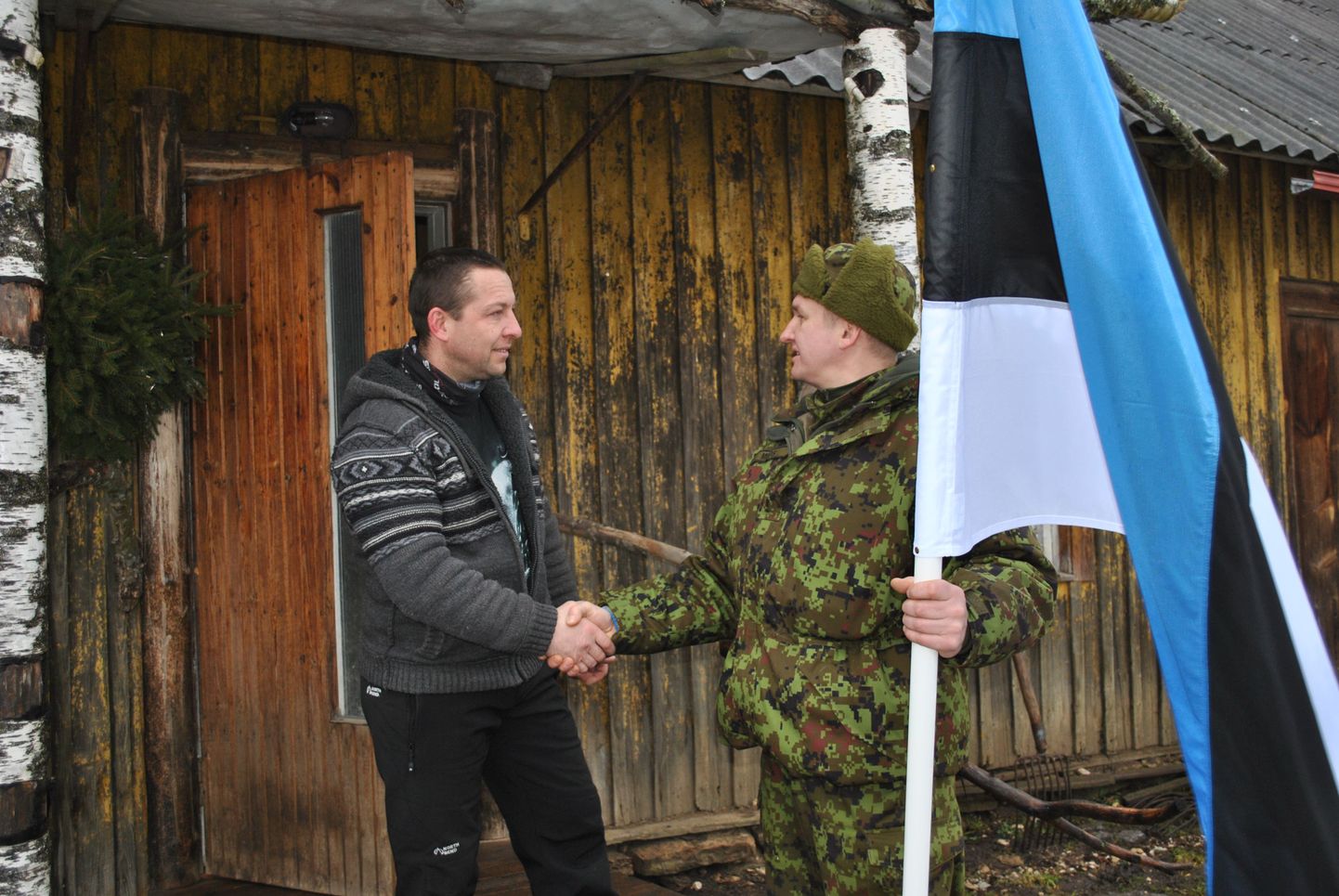 Raul Meos kingib lipu Roosna-Alliku vallas Tuljo Martinile, Tuljojaagu talu peremehele.