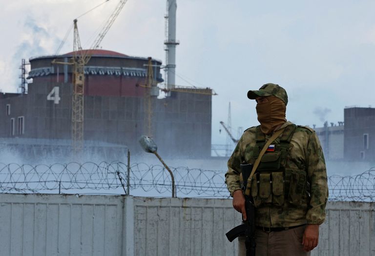 Военнослужащий с российским флагом на форме стоит на посту возле Запорожской атомной электростанции в оккупированном Россией городе Энергодар Запорожской области, Украина, 4 августа 2022 года