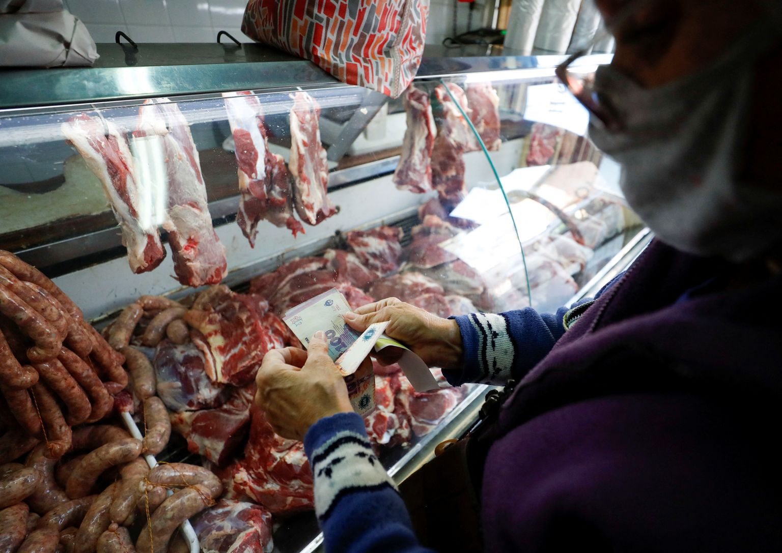 Аргентинский покупатель перед мясным прилавком.