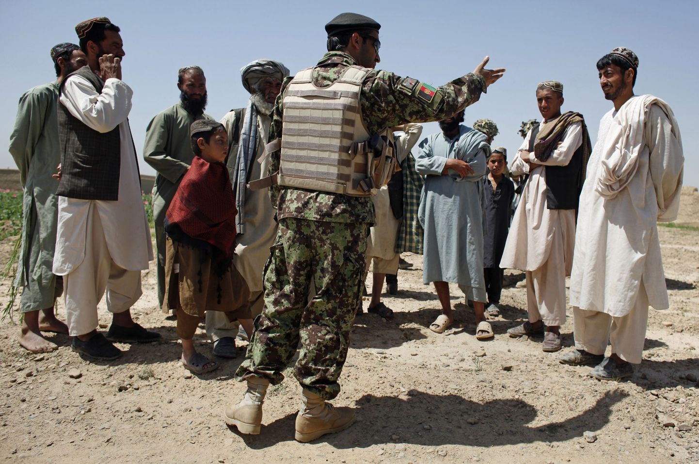 Afganistani sõjaväe ohvitser selgitamas Kandahari põllumeestele, et nood peavad oma moonipõllud hävitama.