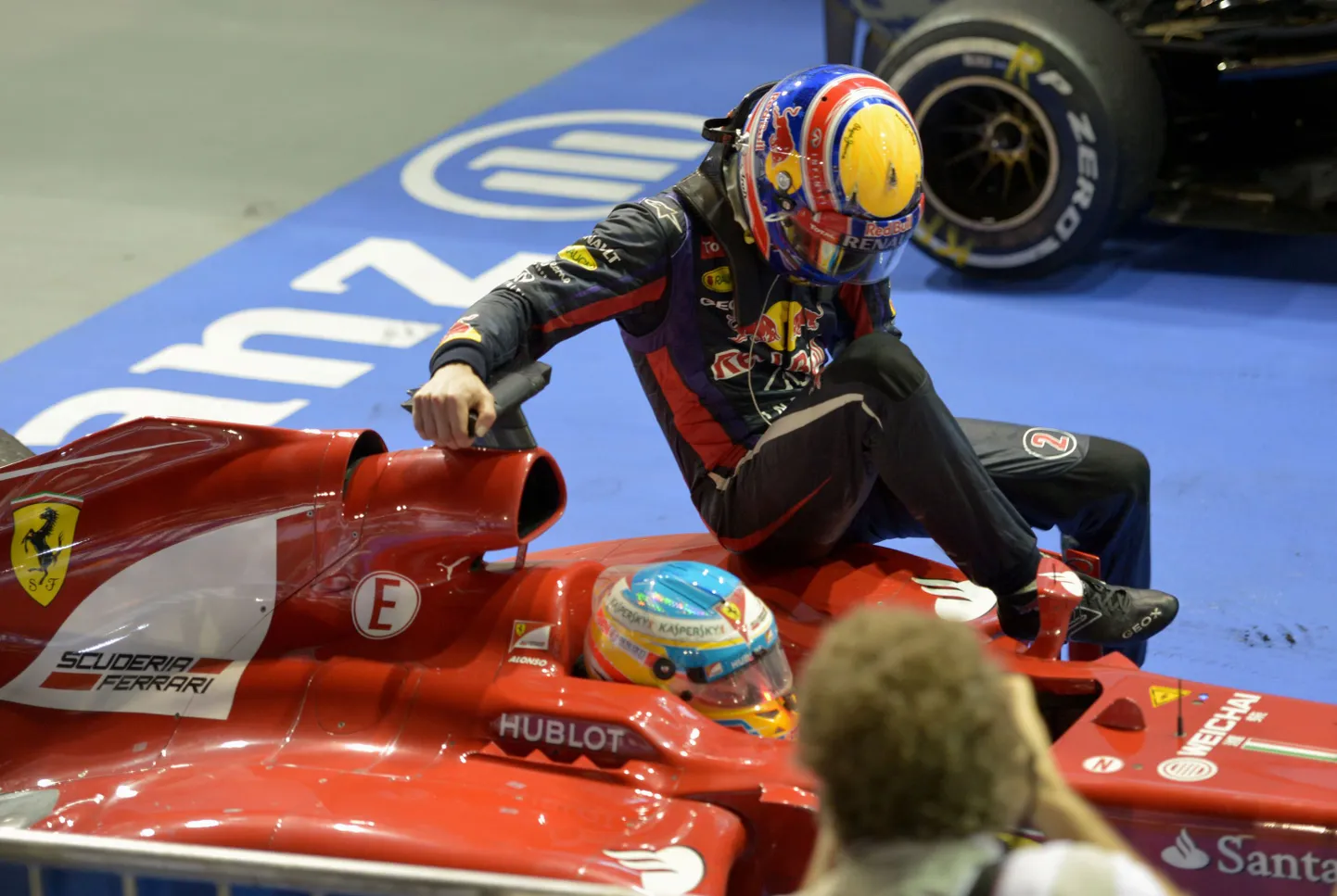 Mark Webber saabumas boksialasse Fernando Alonso auto kerel istudes.