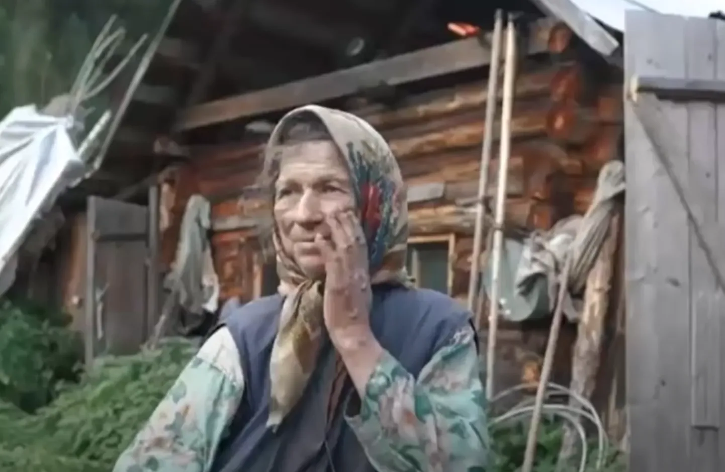 Агафья Лыкова на фоне старого дома.