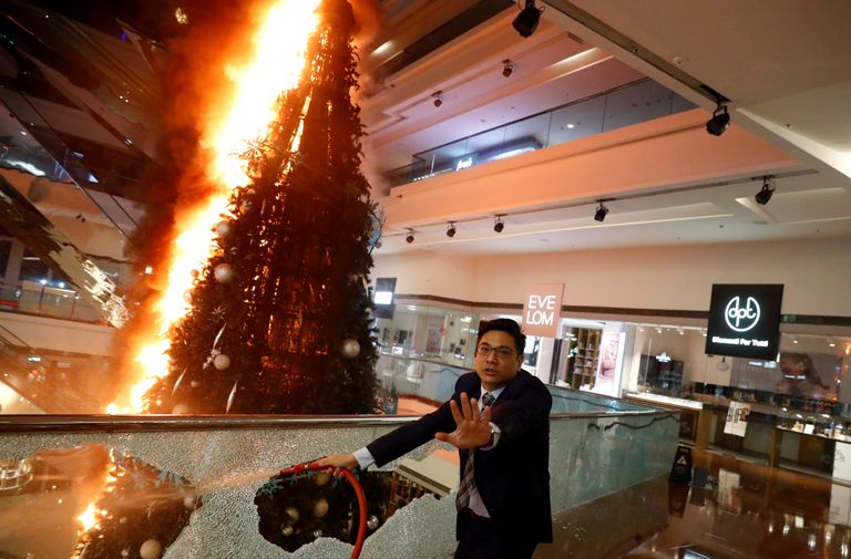 Mees üritab kustutada Festival Walki kaubanduskeskuses süüdatud jõulupuud.