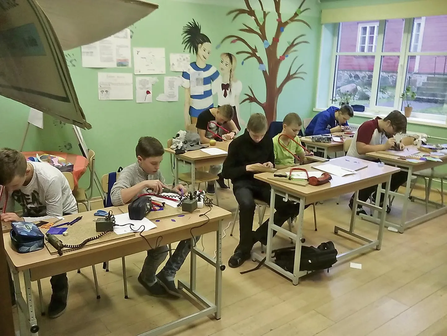Kihnu poisid valmistavad tööõpetuse tunnis külmkapimagneteid.