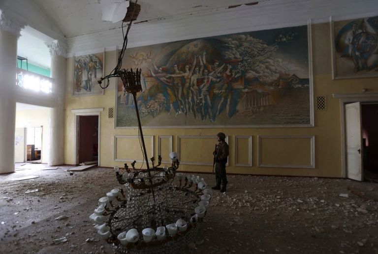 Украинский военный осматривает разрушенный дом культуры в Рубежном, 8 апреля 2022 года