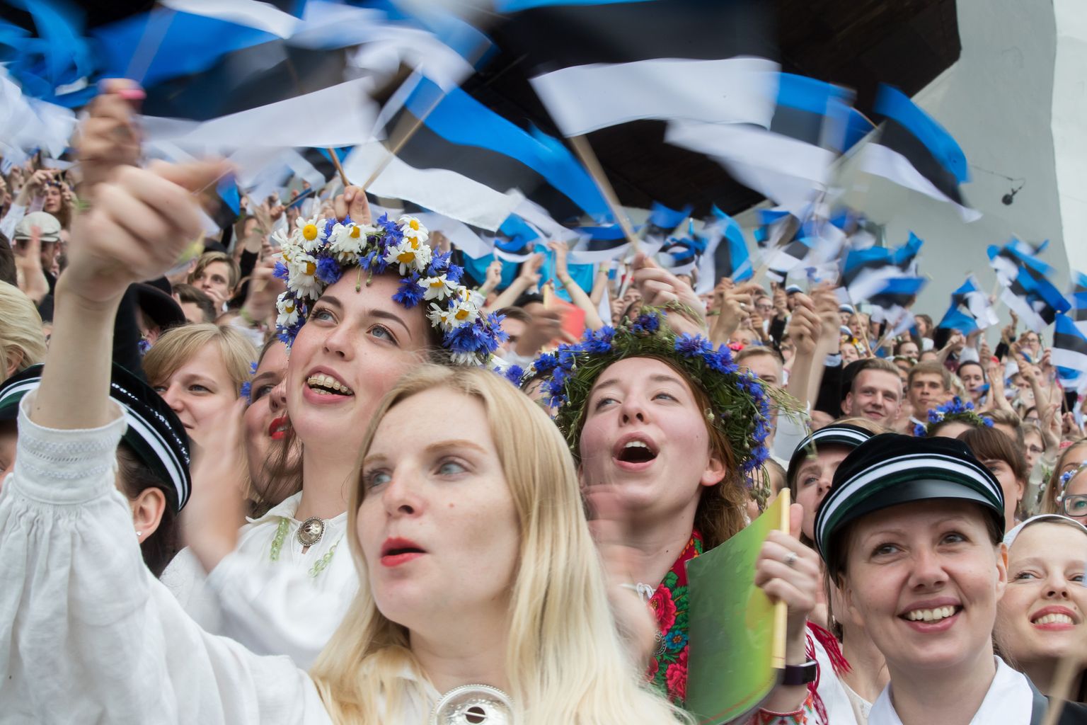 Люди размахивают флагами Эстонии. Фото иллюстративное.