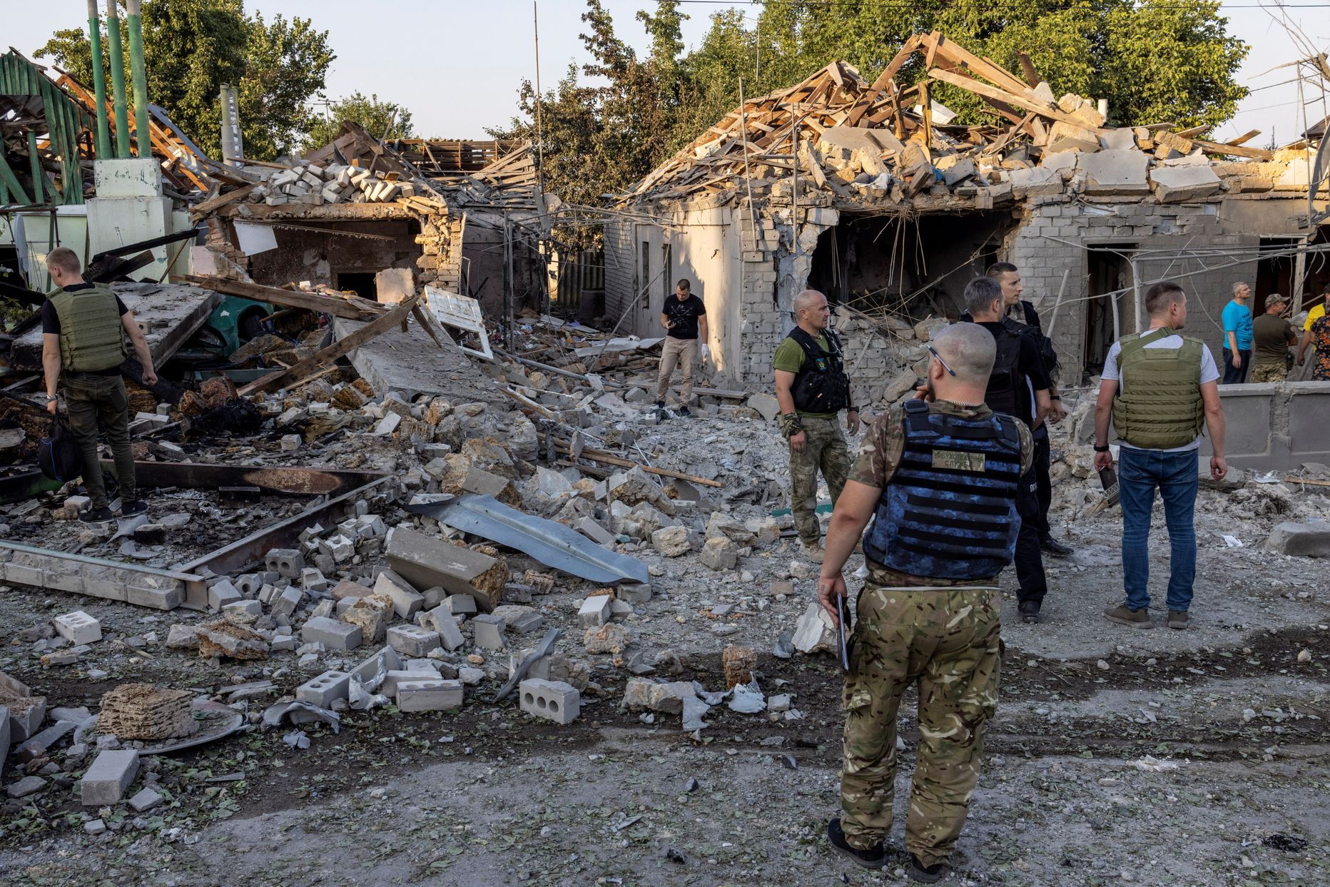 Politseinikud ja sõjaväelased vaatavad purustatud maju Mõkolajivis.