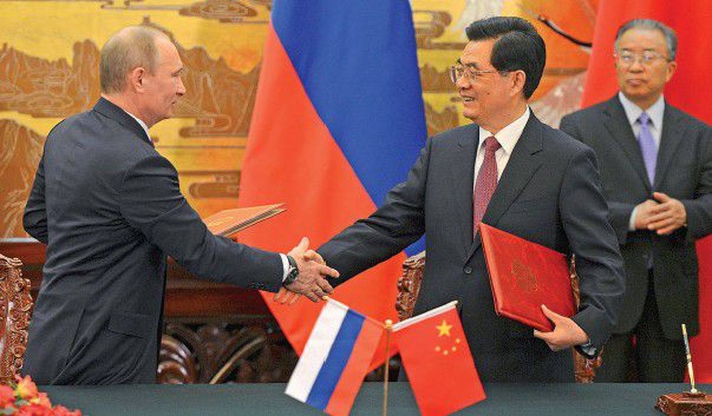 Президент России Владимир Путин (слева) обменивается рукопожатием с председателем КНР Ху Цзиньтао во время церемонии подписания в Пекине совместного заявления.