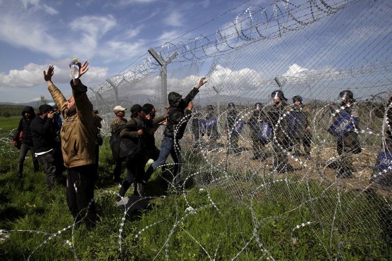Protesteerivad migrandid lõhkumas piiritara Kreeka-Makedoonia piiril 2016. aastal. 