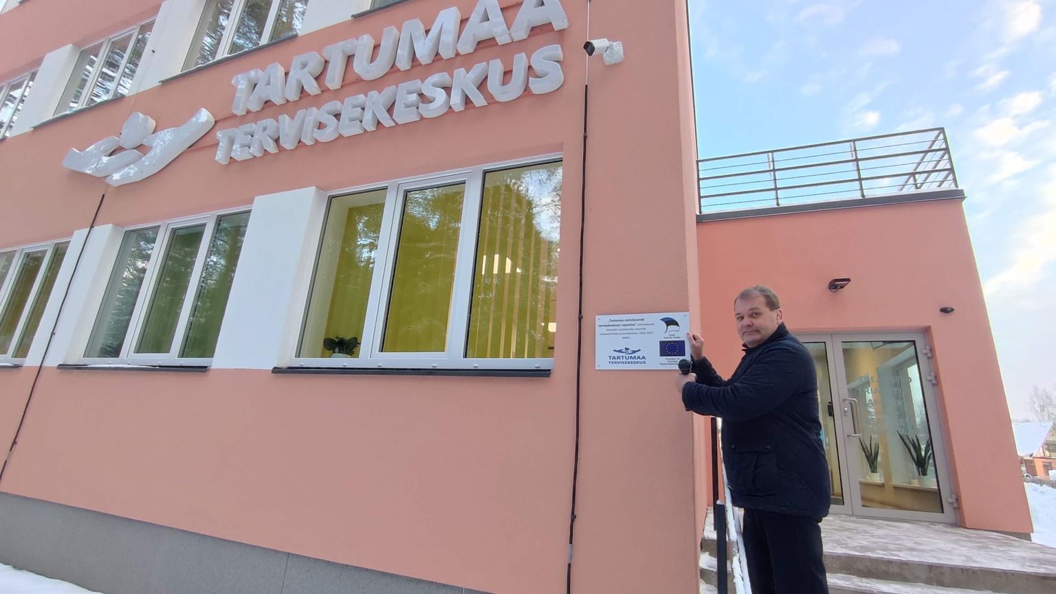 Пеэтер Лаасик, заведующий Эльваской больницы, прикрепляет табличку с именами доноров на стену открывшегося Тартумааского центра здоровья.
