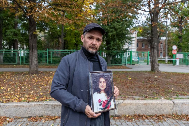 Андрей Гриценко держит портрет дочери, погибшей в его доме в результате взрыва ракеты.