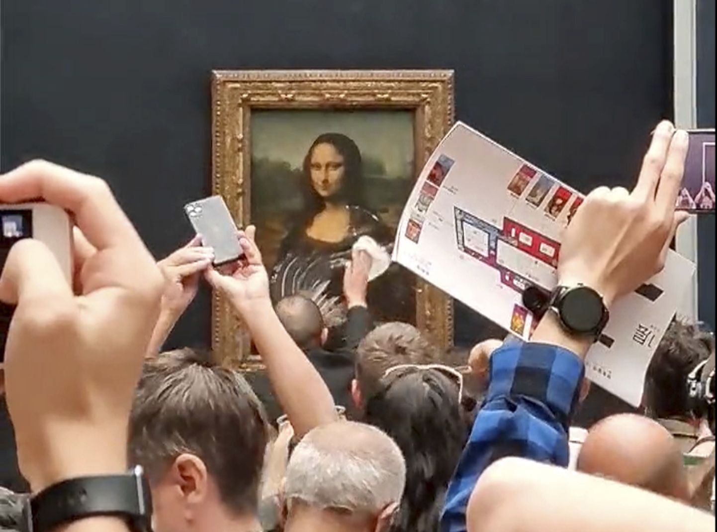Turvamees puhastab Louvre'is koogirünnaku alla langenud «Mona Lisat» kaitsvat klaasi.