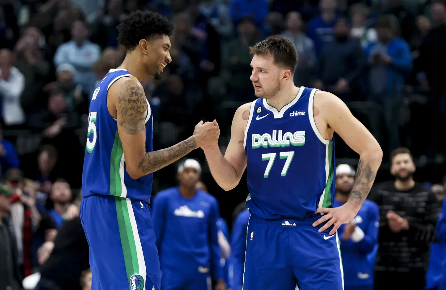 Luka Dončičs (pa labi) un Kristians Vuds.