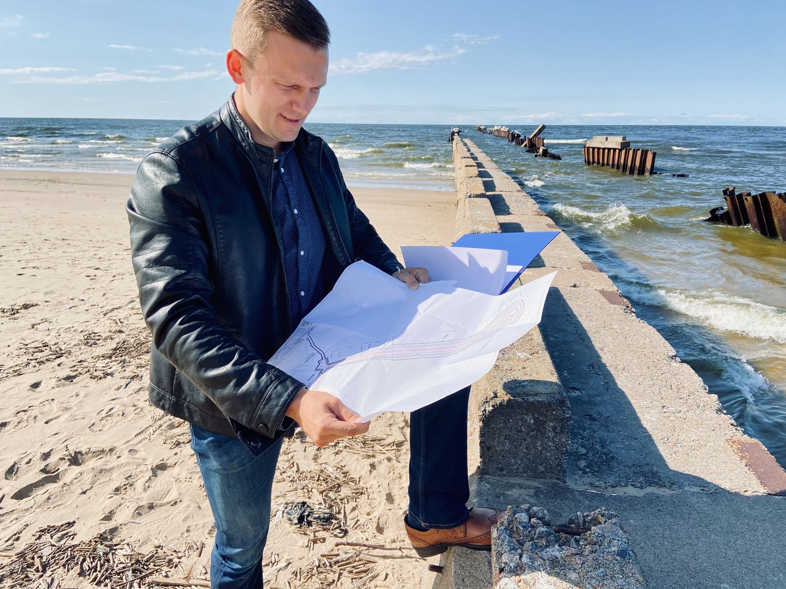 Мэр Нарва-Йыэсуу Максим Ильин с рабочим проектом нового морского мола - у основания старого разрушенного мола.