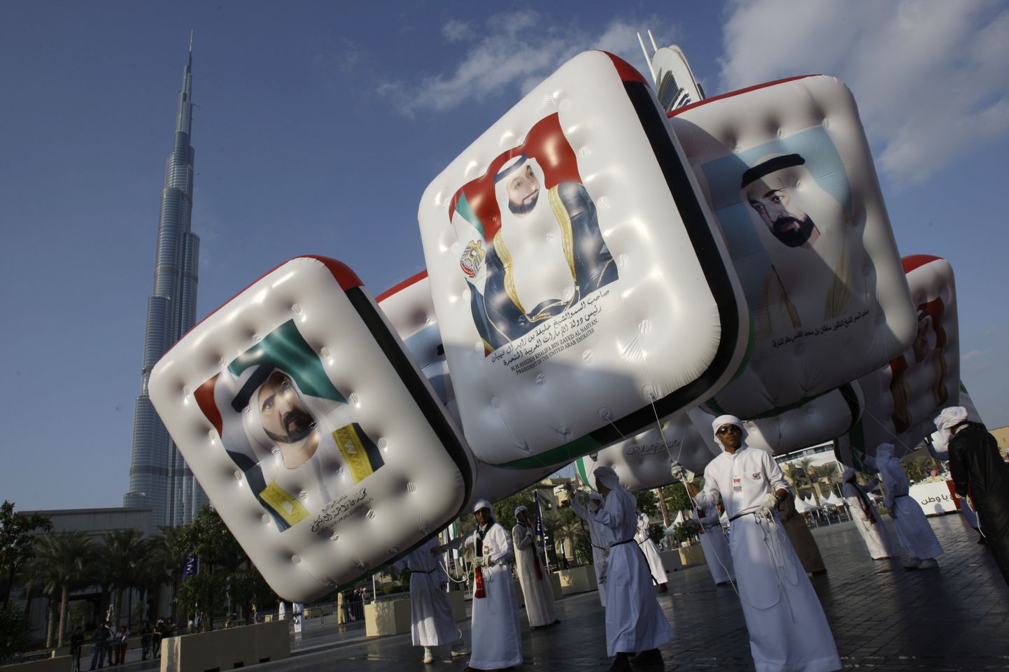 Mehed eilsel Araabia Ühendemiraatide rahvusvpäeval Dubais juhtide piltidega plakateid kandmas. Šeik Mohhamed kinnitas eile ajakirjanikele, et välismaailm ei saa Dubais toimuvast midagi aru ning tegelikult on majandus tugev ja heal järjel.