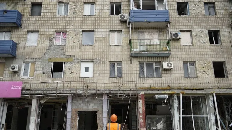Люди затягивают окна пленкой, чтобы сохранить тепло в квартире