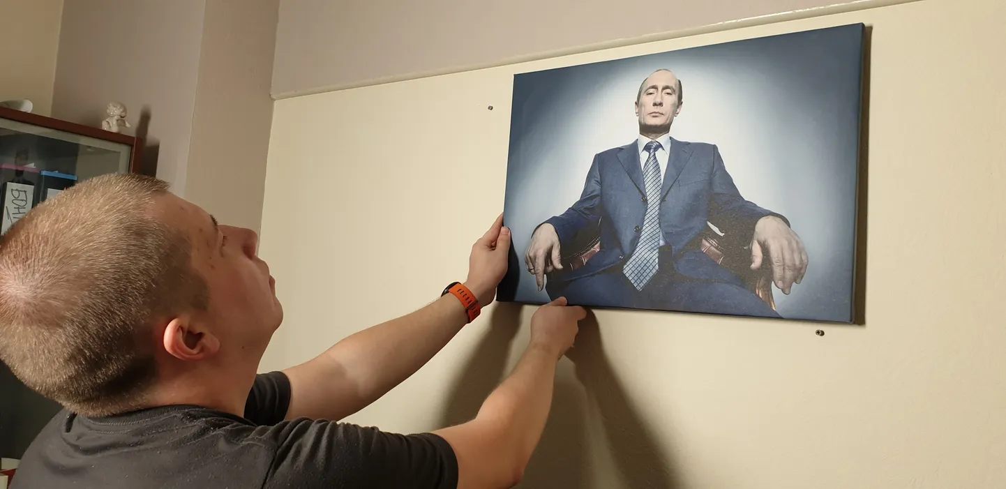 Mees Putini pilti seinale sättimas.