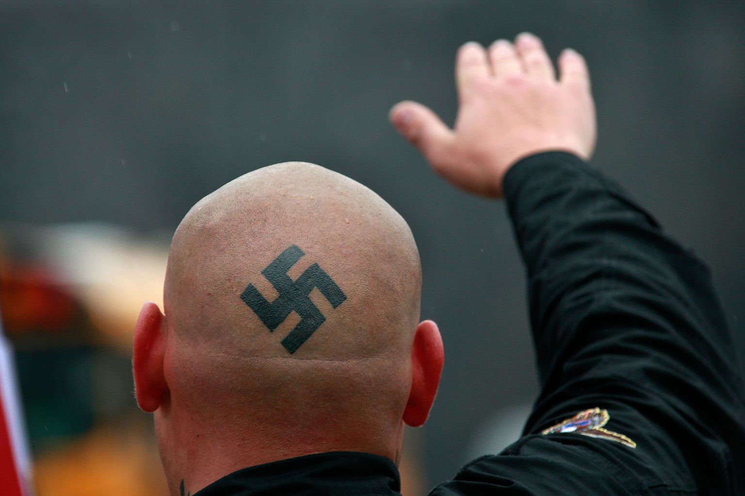 Неонацист с татуировкой свастики.