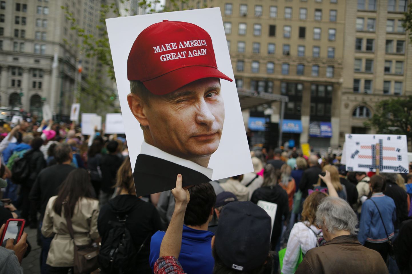 Meeleavaldaja New Yorgis kannab plakatit, millel Putinil on peas Trumpi kampaaniamüts.