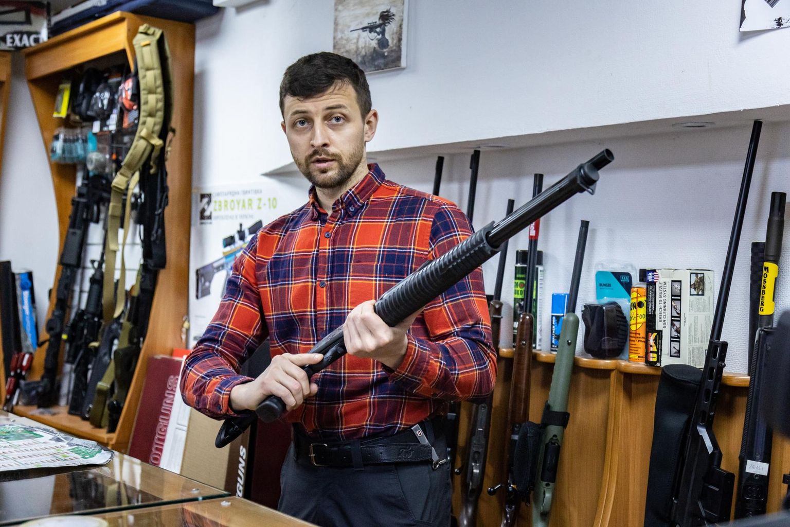 Relvakaupmees Oleksandr Avksentijev hoiab käes Ukrainas ülipopulaarset Türgi pumppüssi Hatsan, milline on kodus ka mehel endal.