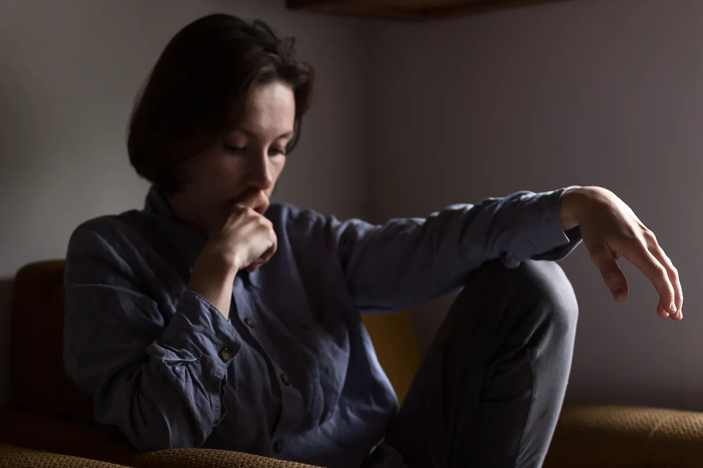Lonely sad young woman depressed and stressed sitting in the dark bedroom.gray tone, selective focus and toning.Negative emotion, postpartum depression  concept