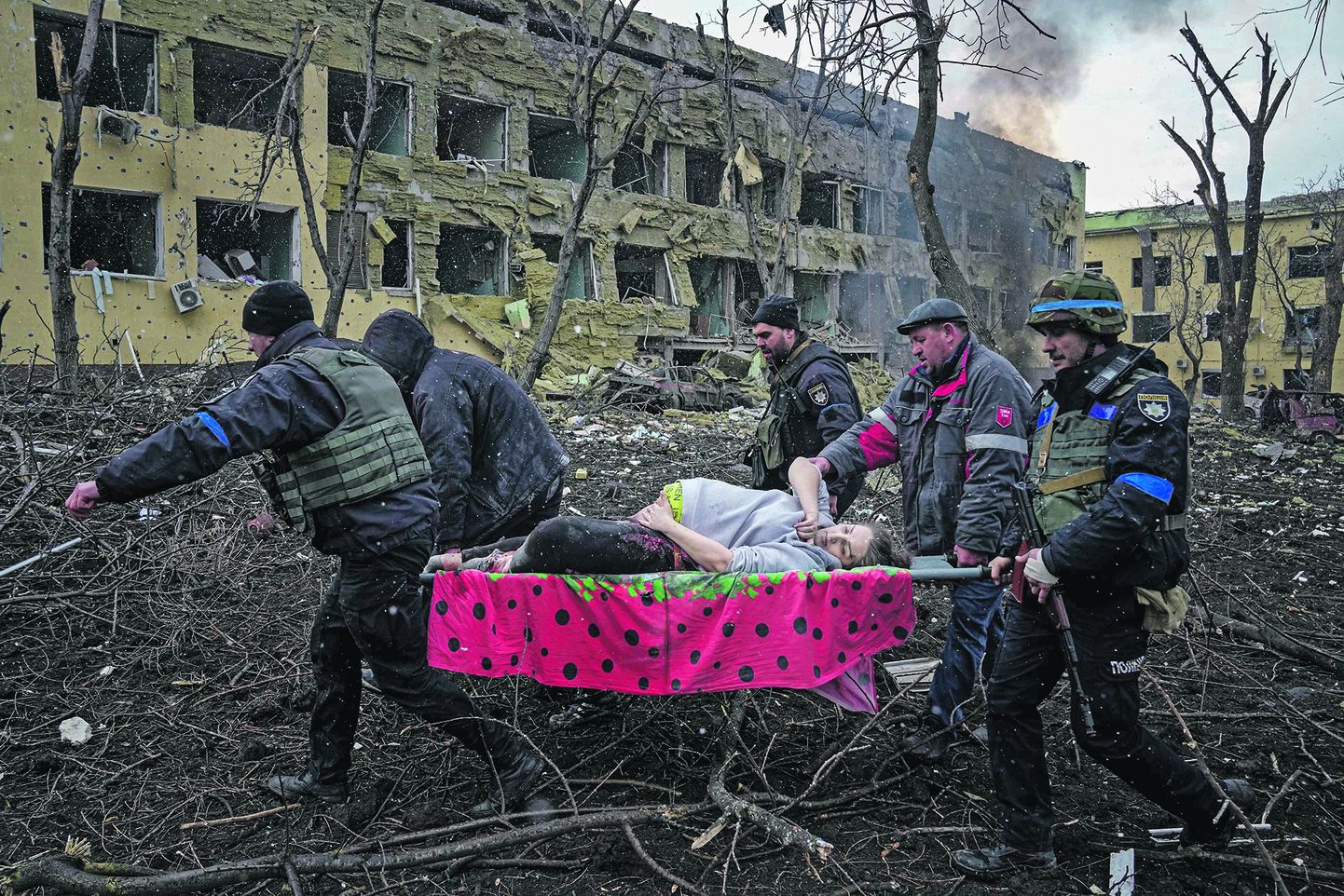 Волонтеры выносят раненых из родильного дома в Мариуполе после ракетной атаки российских войск 9 марта 2022 года.