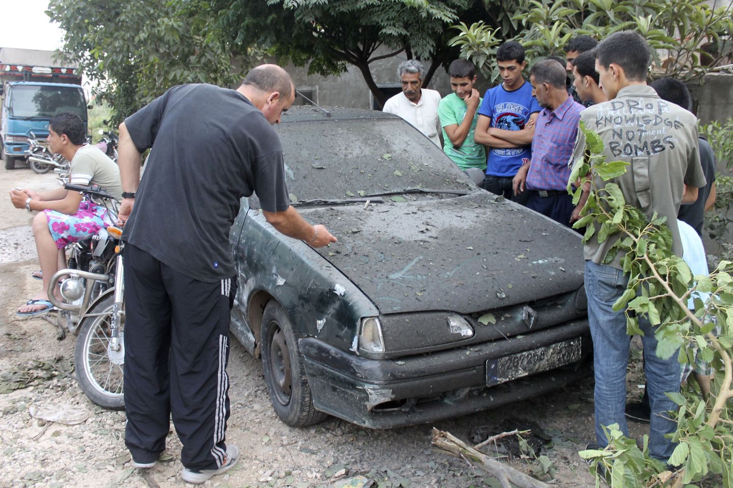 Külaelanikud Põhja-Liibanonis Wadi Khaledis raketirünnakus kahjustada saanud auto juures.