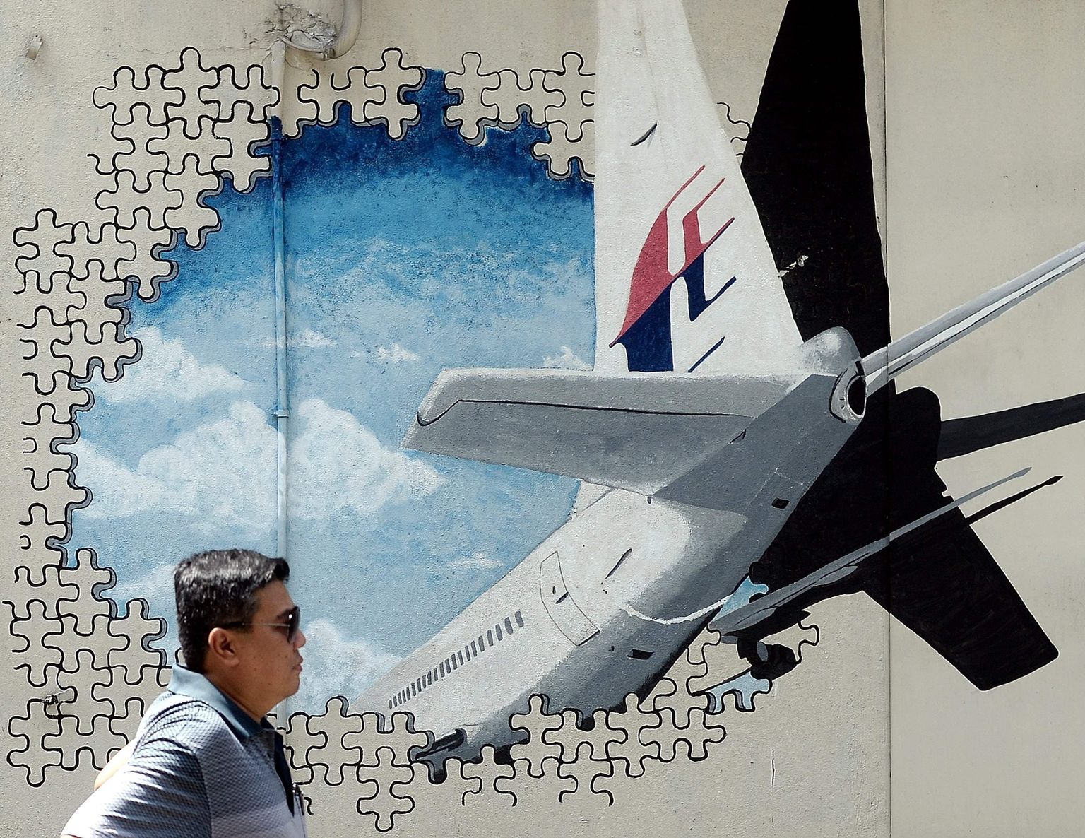 Malaisia mees täna Shah Alamis müürijoonistuse ees, mis on pühendatud MH370 mõistatuslikule kadumisele.
