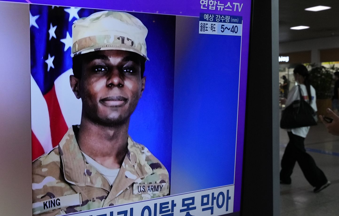 Travis King Lõuna-Korea raudteejaama teleekraanil.