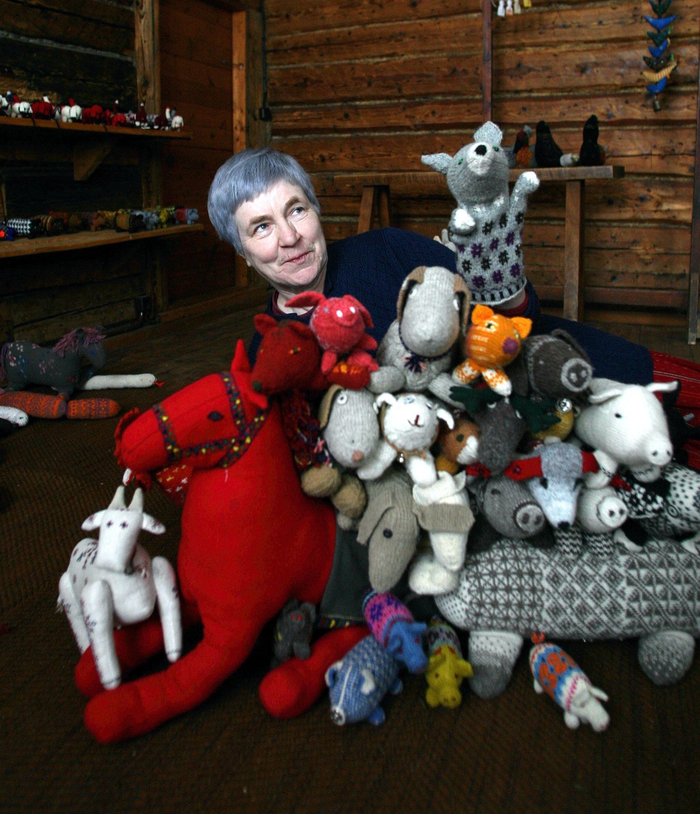 Kunstnik Anu Raud oma muuseumis kootud rahvuslike mänguasjade keskel.