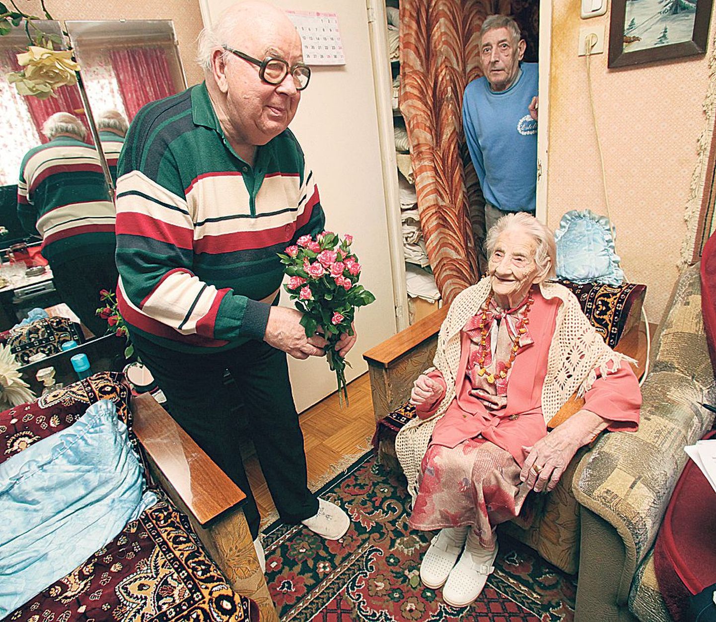 101-aastane Elfriede Barth eile koos kahe pojaga. Jaan Märtin roosidega esiplaanil ja Avo Barth seismas uksevahes.