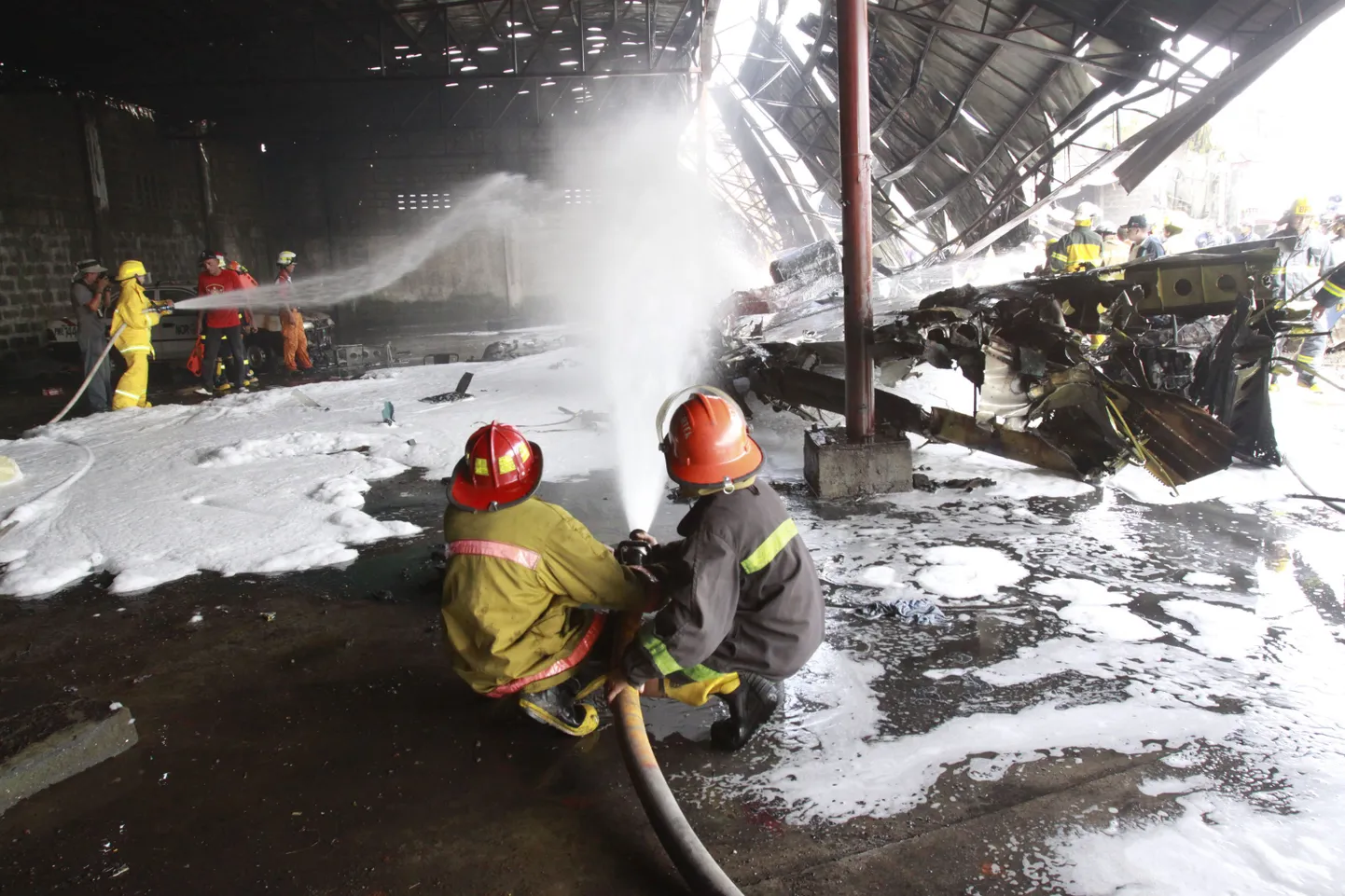 Filipiinide tuletõrjujad kustutavad Las Pinase eeslinna kukkunud lennukit.