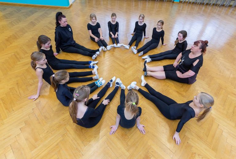 Jakobsoni kooli balletistuudio lapsed ja õpetajad Katrin Hommik ning Marit Neering enne treeningu algust soojendusharjutusi tegemas.
 