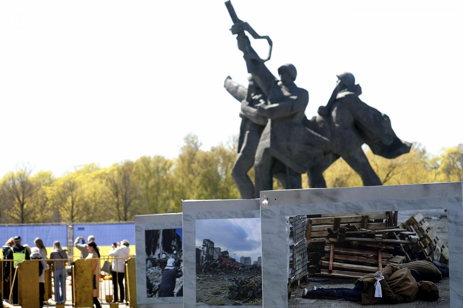 Riia Võidu monument ühes Ukraina sõjaõudusi kujutavate fotodega. 