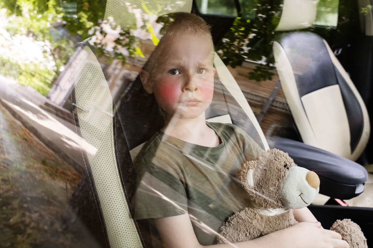 Laps kinniste akendega ja pargitud autos. Pilt on illustreeriv