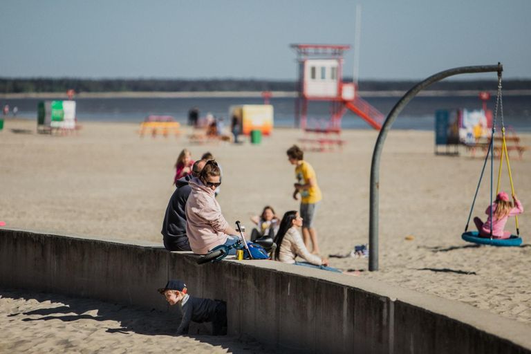 Солнечный день привлек людей на пляж. Прибрежные кафе и пункты проката делают последние приготовления к летнему сезону.
