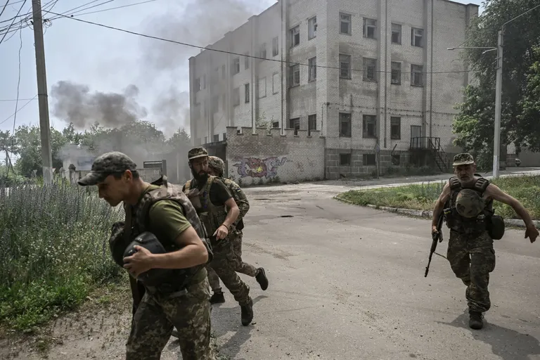 Ukraina teenistujad jooksmas varju Vene suurtükitule eest Lõssõtšanskis 11. juunil.