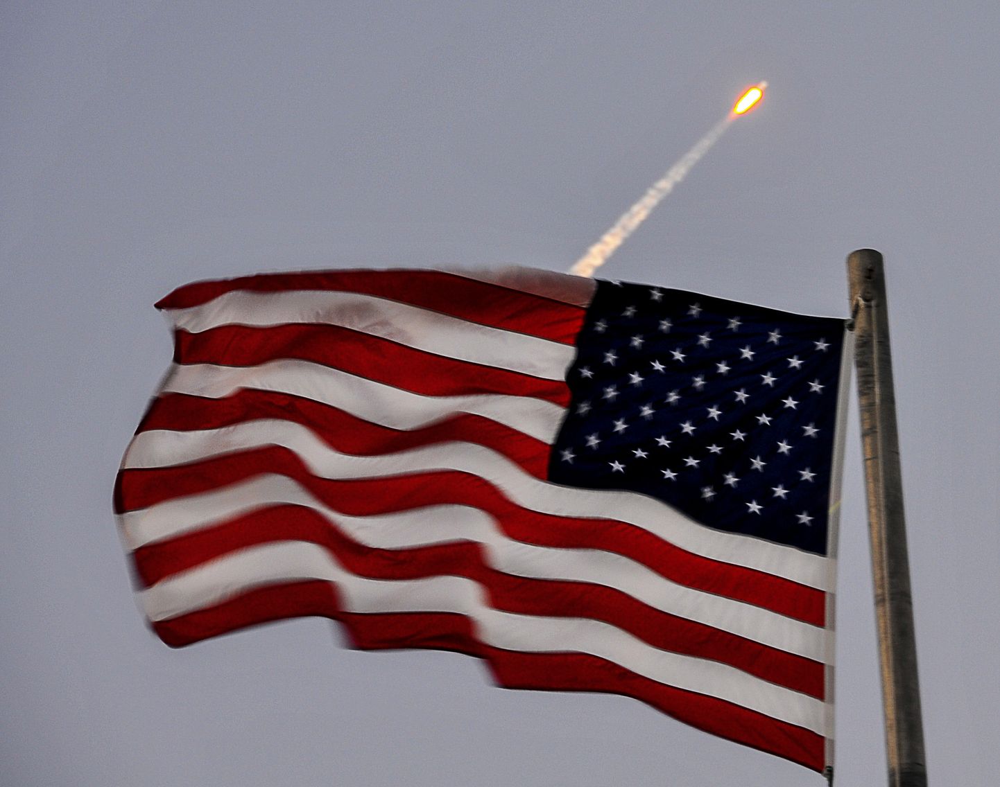 Kosmoseraketi SpaceX Falcon 9 start. Esiplaanil USA lipp.