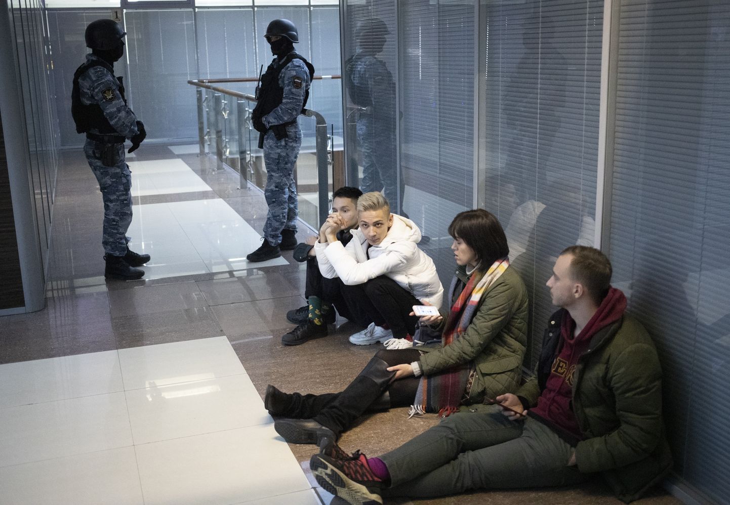 Opozicionāra Alekseja Navaļnija dibinātā Krievijas Pretkorupcijas fonda darbinieki sēž uz grīdas, kamēr policija veic kratīšanu birojā