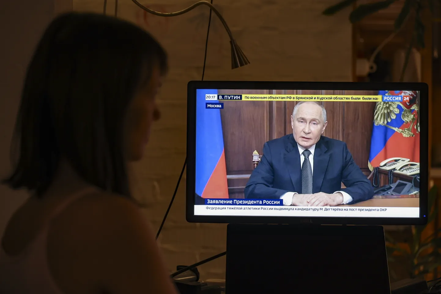 Женщина в публичном месте смотрит телевизионное обращение президента РФ Путина, который признал удар баллистической ракетой по Украине, 21 ноября 2024 года, Москва, Россия.