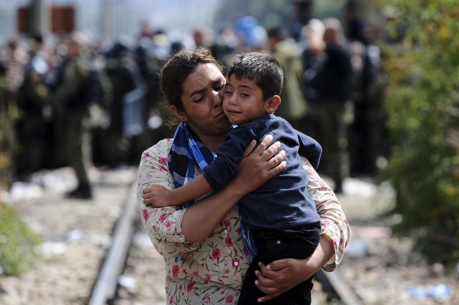 Süüria naine kandmas oma poega üle Kreeka-Makedoonia piiri.
