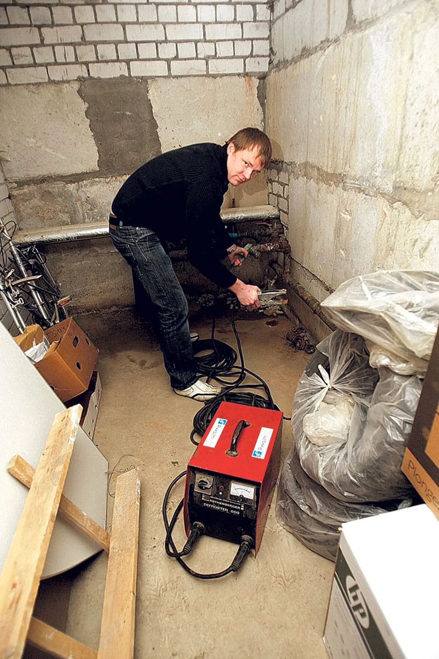 Marti Nurmine näitab elektriseadeldist, millega saab lahti sulatada külmunud metalltorusid.